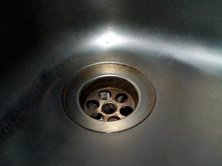 Round metal drain in a stainless steel sink